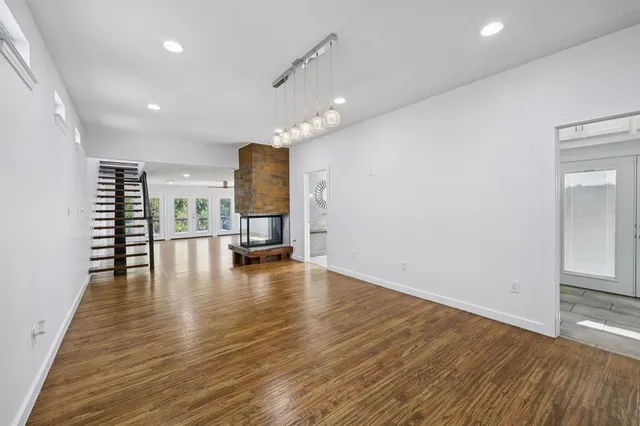 a living room with furniture floor to ceiling window and wooden floor