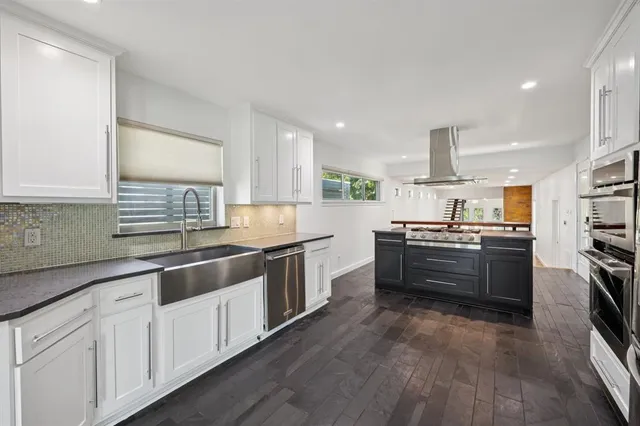 a kitchen with a refrigerator a sink and a stove top oven