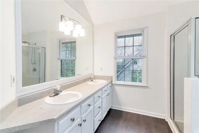 a bathroom with double sink and a window