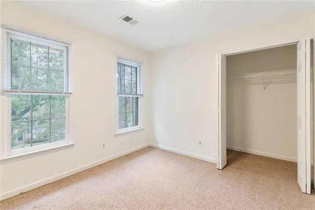 an empty room with windows and closet