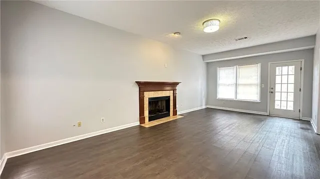 an empty room with wooden floor and fireplace