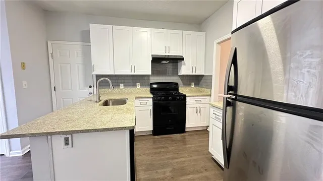a kitchen with a refrigerator a stove and a refrigerator with wooden floor