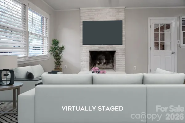 a living room with furniture a large window and a fireplace