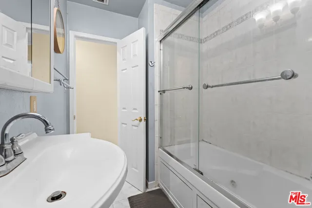 a bathroom with a tub shower sink and vanity