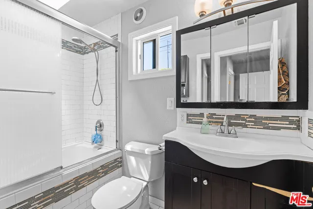 a bathroom with a sink toilet mirror and shower