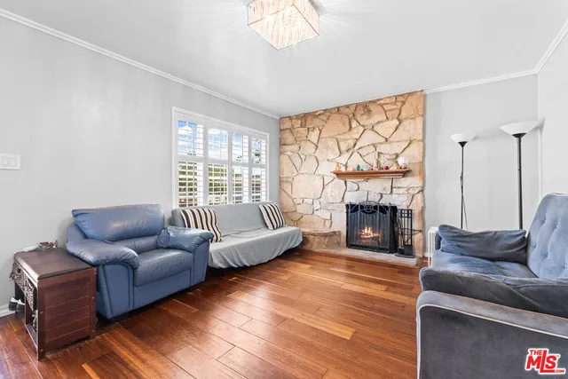 a living room with furniture a fireplace and a large window with wooden floor