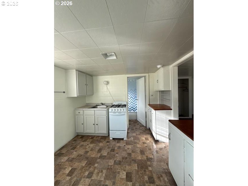 1908 Adams Avenue La Grande, OR 97850 - Photo 6 of 12 a large white kitchen with a stove a sink and a refrigerator