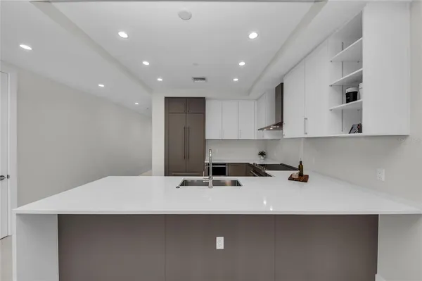 a kitchen with stainless steel appliances granite countertop white cabinets and a stove a oven with white countertops