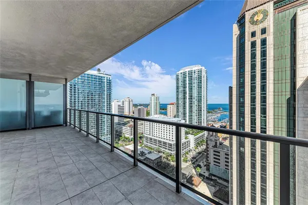 a bedroom with a bed painting on wall and a potted plant
