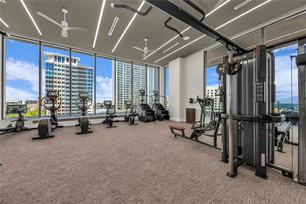 a kitchen with stainless steel appliances kitchen island granite countertop a dining table chairs and white cabinets