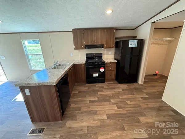 a kitchen with granite countertop a refrigerator and a stove top oven