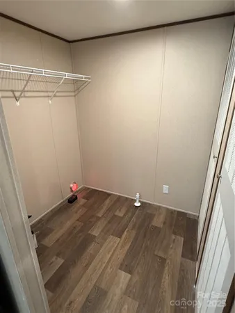 a view of a room with wooden floor and cabinets