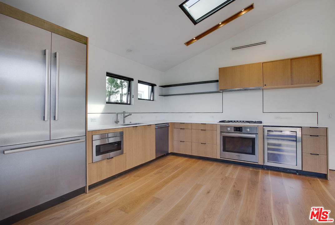 800 7th Avenue Venice, CA 90291 - Photo 9 of 28 a kitchen with stainless steel appliances and wooden cabinets