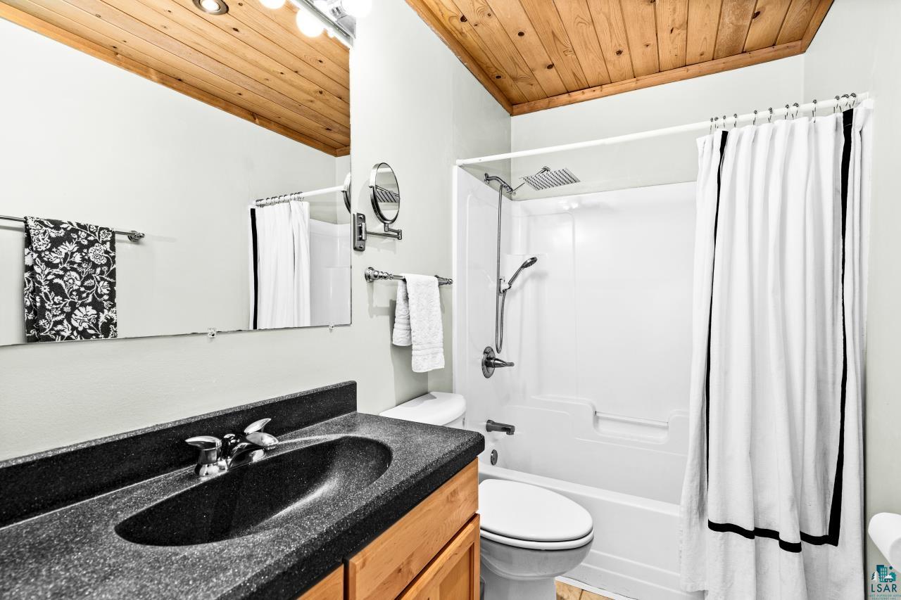 67 Snowshoe Trail Tofte, MN 55615 - Photo 10 of 42 Full bathroom featuring wooden ceiling, vanity, and shower / tub combo