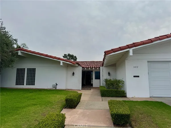 a front view of a house with a garden and plants