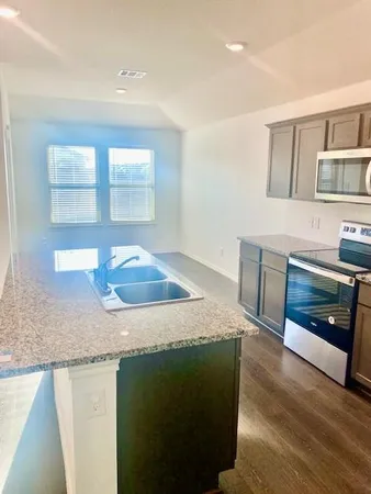 a kitchen with stainless steel appliances granite countertop a sink and a granite counter tops