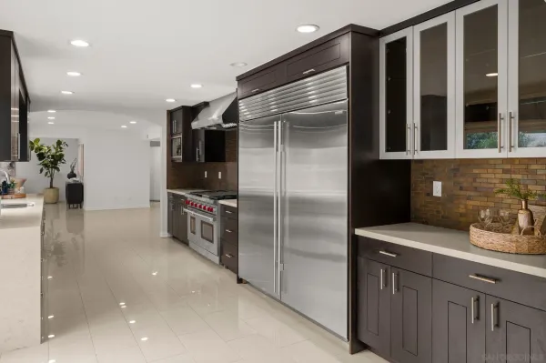 a kitchen with stainless steel appliances granite countertop a refrigerator and a sink