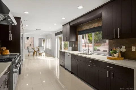 a kitchen with stainless steel appliances granite countertop sink stove refrigerator and cabinets