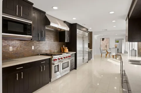 a kitchen with stainless steel appliances a stove a sink a microwave a refrigerator and cabinets