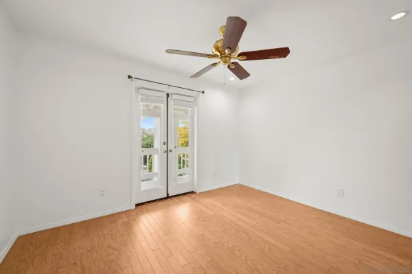 a view of a big room with wooden floor and a ceiling fan