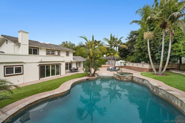 a view of a house with backyard and sitting area