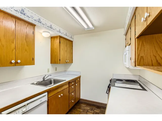 a living room with a table chairs and a refrigerator
