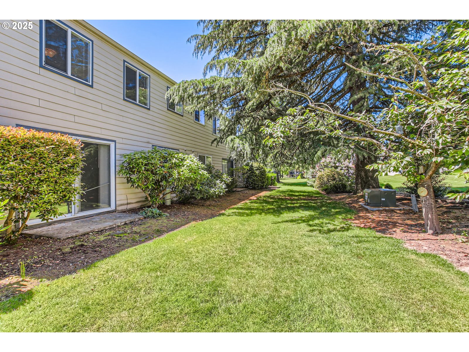 220 Northeast Village Squire Avenue, Unit 12 Gresham, OR 97030 - Photo 27 of 29 a backyard of a house with plants and large tree