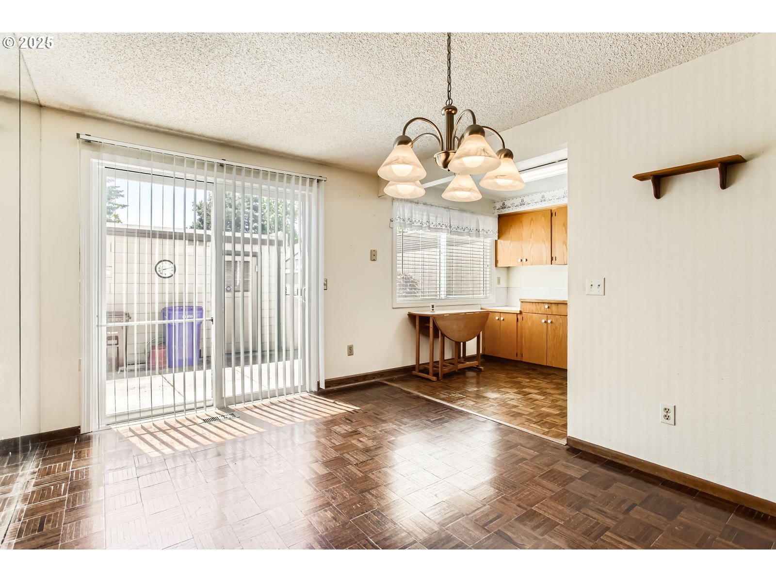 220 Northeast Village Squire Avenue, Unit 12 Gresham, OR 97030 - Photo 10 of 29 a view of a livingroom with a dinning area hardwood floor and a chandelier