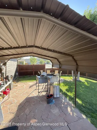 a view of yard with table and chairs a barbeque with wooden fence