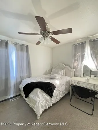 a spacious bedroom with a bed and a chandelier