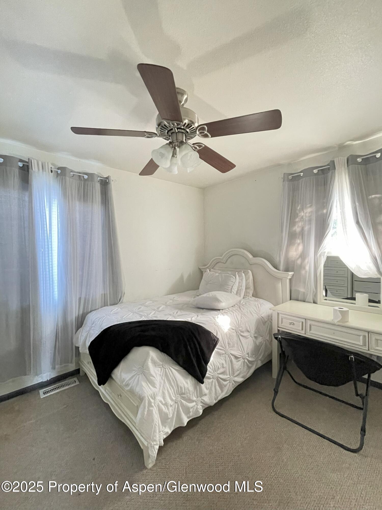 2203 Ute Avenue Rifle, CO 81650 - Photo 9 of 12 a spacious bedroom with a bed and a chandelier