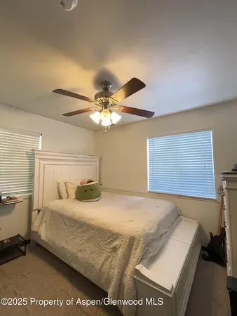 a bedroom with a bed and ceiling fan