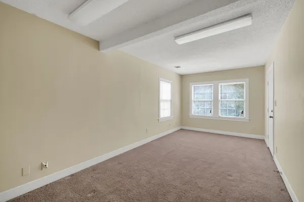 a view of a big room with windows and chandelier fan