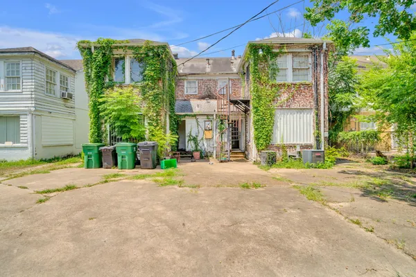 a front view of a house with a yard and potted plants