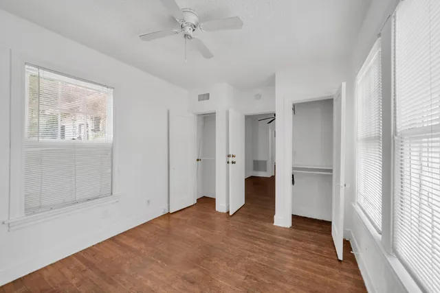a view of empty room with wooden floor and window