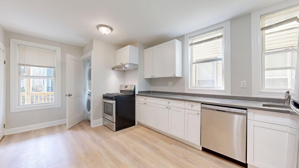 205 Chelsea Street, Unit 3 Boston, MA 02128 - Photo 13 of 33 a kitchen with granite countertop white cabinets and white appliances