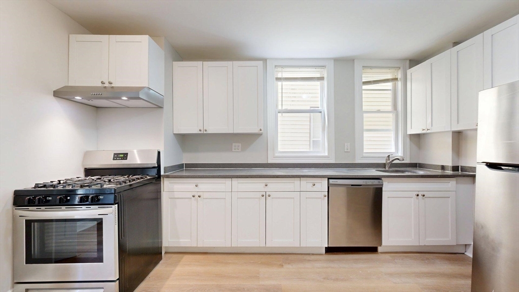 205 Chelsea Street, Unit 3 Boston, MA 02128 - Photo 16 of 33 a kitchen with stainless steel appliances granite countertop a stove a sink and a microwave