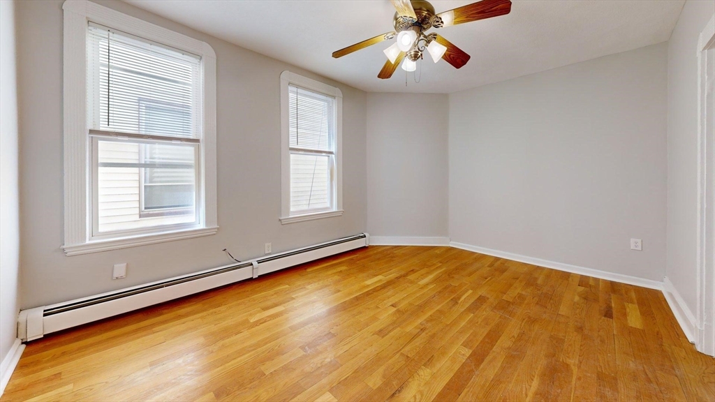 205 Chelsea Street, Unit 3 Boston, MA 02128 - Photo 21 of 33 a view of an empty room with chandelier fan and wooden floor