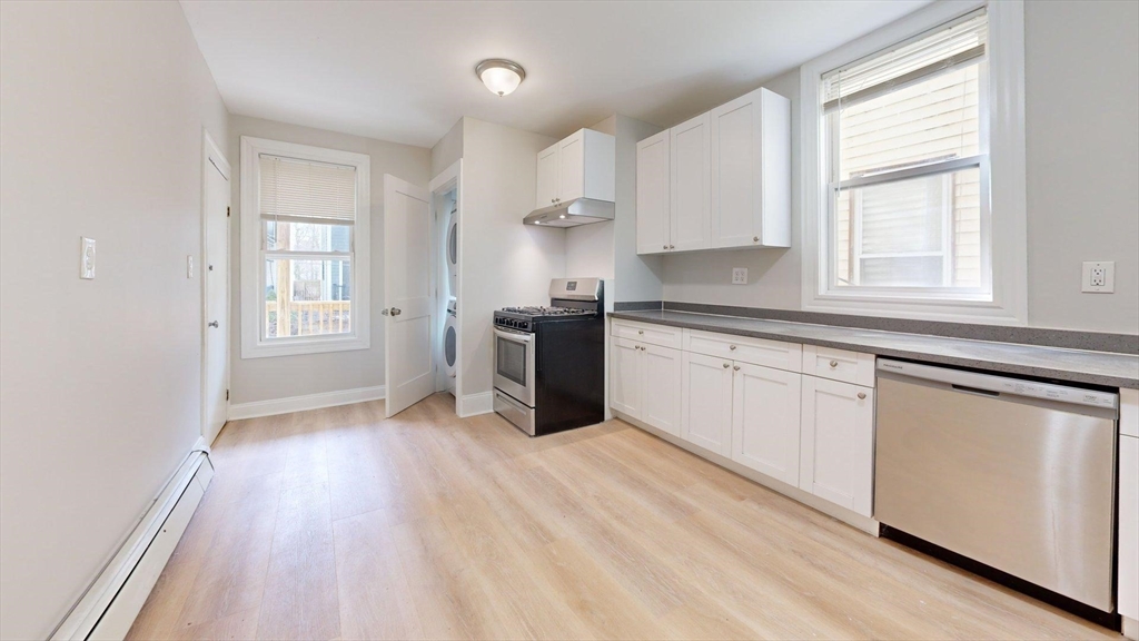 205 Chelsea Street, Unit 3 Boston, MA 02128 - Photo 27 of 33 a kitchen with stainless steel appliances granite countertop a stove a sink and white cabinets with wooden floor