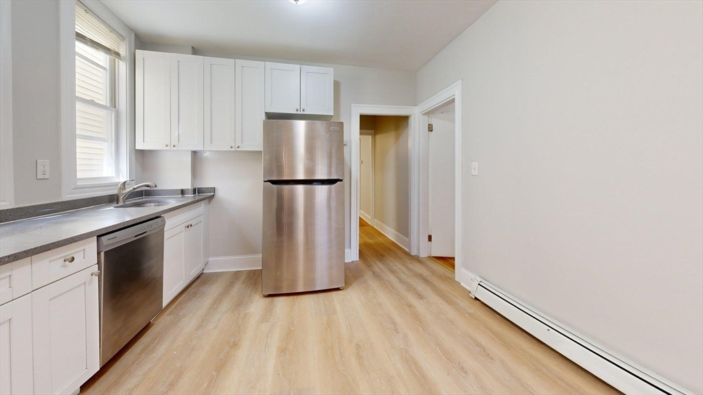 205 Chelsea Street, Unit 3 Boston, MA 02128 - Photo 28 of 33 a kitchen with a sink a refrigerator and a stove