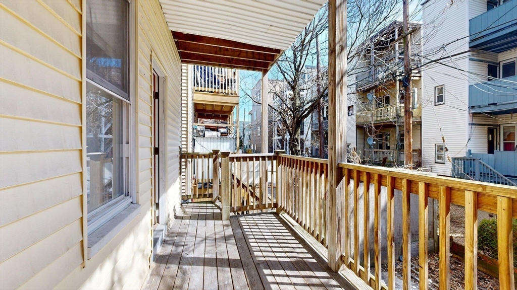 205 Chelsea Street, Unit 3 Boston, MA 02128 - Photo 33 of 33 a view of a balcony with wooden floor and fence and a floor to ceiling window