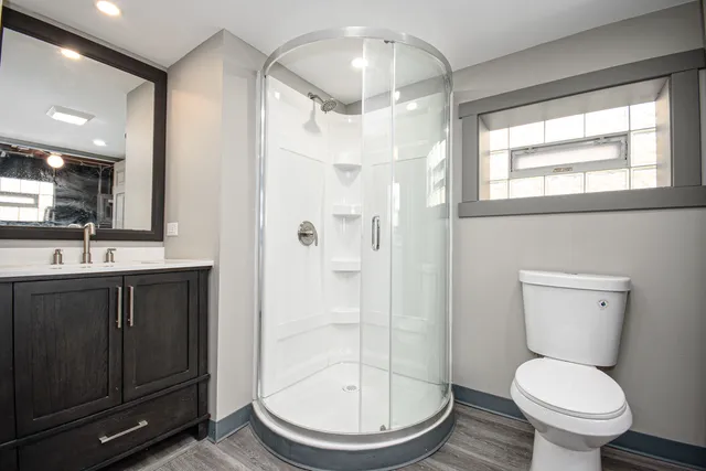 a bathroom with a toilet sink a vanity and shower