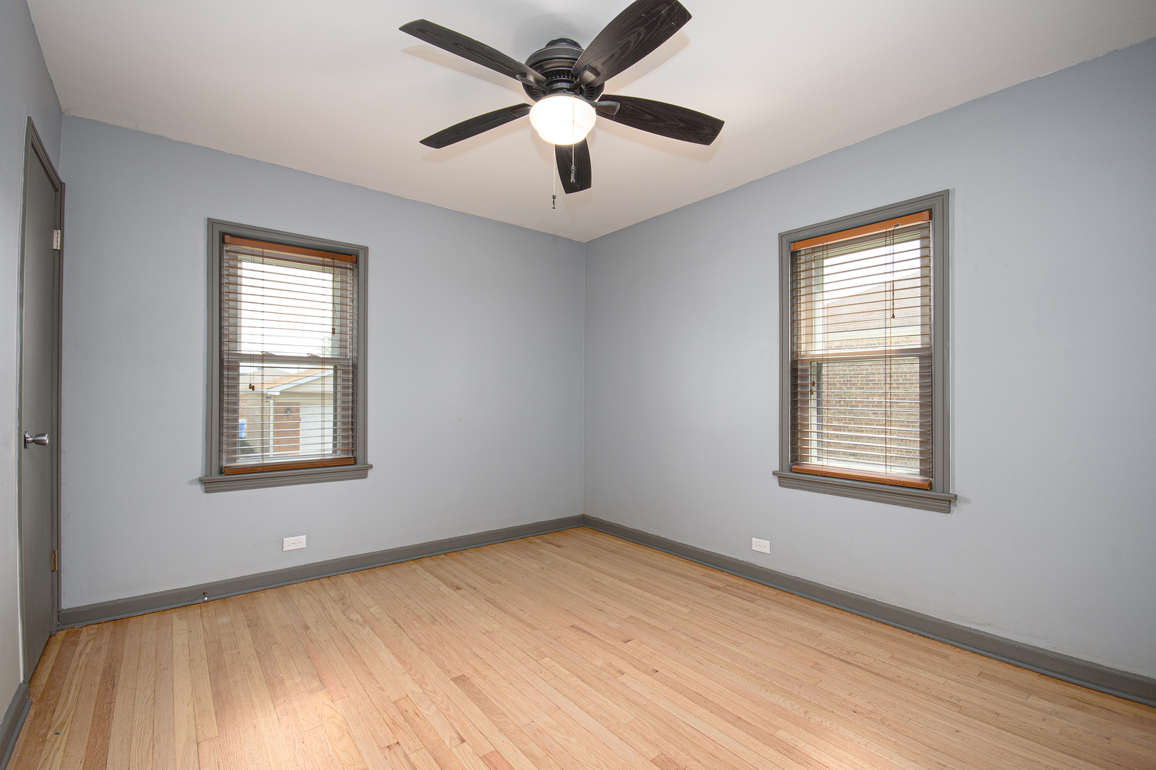 5533 South Menard Avenue Chicago, IL 60638 - Photo 10 of 26 a view of an empty room with a window and a ceiling fan