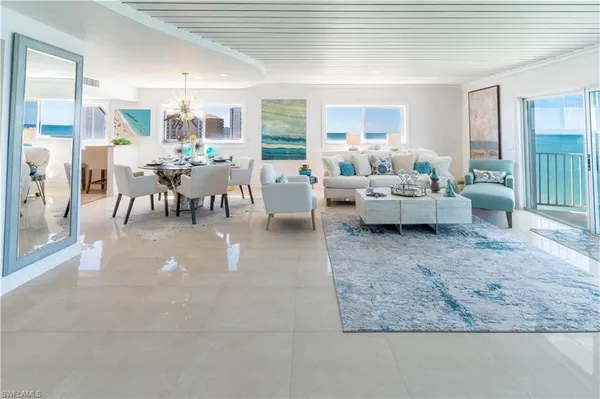 a living room with lots of furniture and view of kitchen