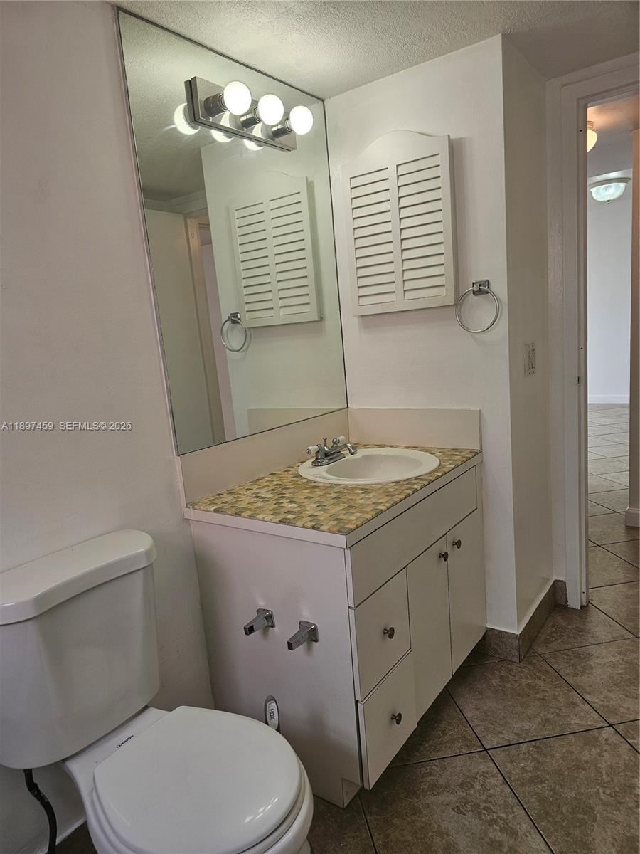 2150 Southwest 16th Avenue, Unit 406 Miami, FL 33145 - Photo 12 of 23 a bathroom with a granite countertop sink toilet a mirror and shower