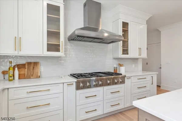 a spacious bedroom with a bed couch chandelier and a window