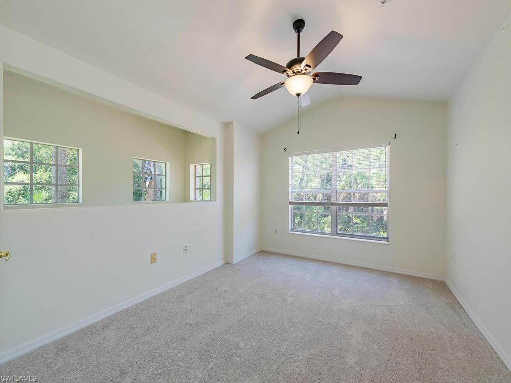 1280 Henley Street, Unit 1601 Naples, FL 34105 - Photo 11 of 15 Empty room featuring carpet floors, ceiling fan, and vaulted ceiling