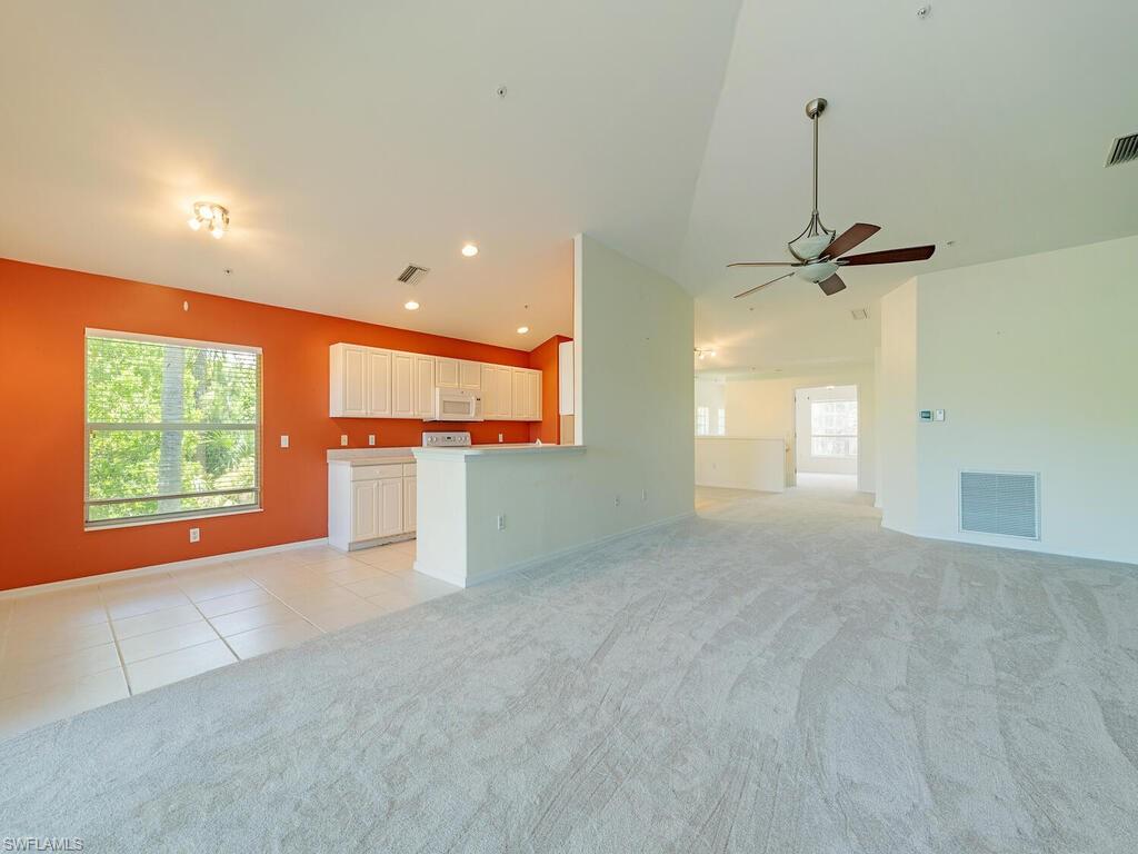 1280 Henley Street, Unit 1601 Naples, FL 34105 - Photo 2 of 15 Unfurnished living room with light carpet, ceiling fan, and lofted ceiling