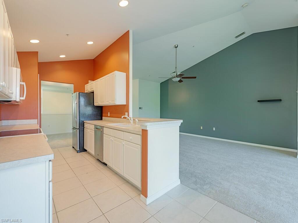 1280 Henley Street, Unit 1601 Naples, FL 34105 - Photo 5 of 15 Kitchen with lofted ceiling, light tile patterned floors, ceiling fan, stainless steel appliances, and sink