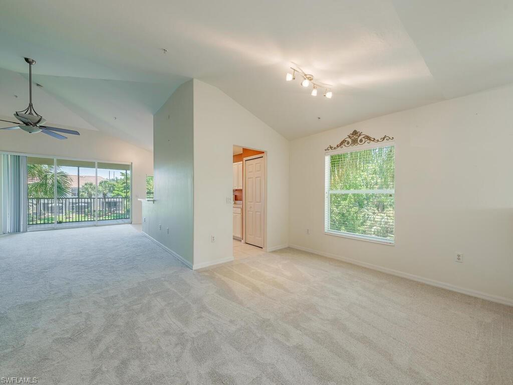 1280 Henley Street, Unit 1601 Naples, FL 34105 - Photo 6 of 15 Unfurnished living room featuring light carpet, a wealth of natural light, ceiling fan, and vaulted ceiling